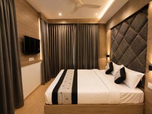 a bedroom with a large bed and a television at Hotel Beverly Palace Santacruz - Near BKC - Mumbai Airport T1 in Mumbai