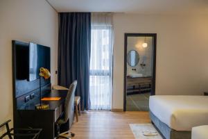 a hotel room with a bed and a desk and a television at Vora Addis Hotel in Addis Ababa