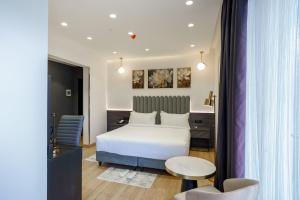 a hotel room with a white bed and a table at Vora Addis Hotel in Addis Ababa