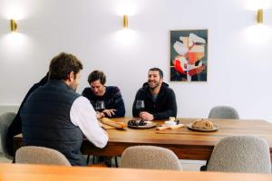 a group of men sitting around a table with food at Outsite Bordeaux - Work, Connect, Explore in Bordeaux +62 photos
