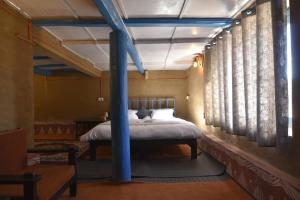 a bedroom with a bed with a blue beam at Idyllic Haven Heritage, Jageshwar in Jageshwar