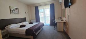 a bedroom with a bed and a desk and a window at Alba Forum in Alba Iulia