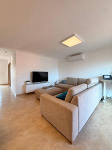 a living room with a couch and a flat screen tv at Villa Roja in Bigastro