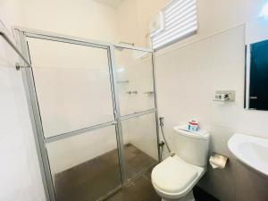 a bathroom with a shower and a toilet and a sink at Nandawanam Guest House Pasikuda in Kalkudah +14 photos