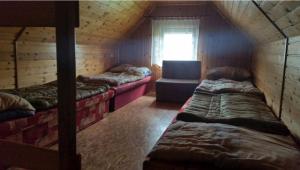 a room with three beds and a chair in a cabin at Apartmán Marcel - Súľov in Súľov