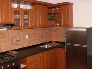 a kitchen with wooden cabinets and a stainless steel refrigerator at Apartmán Marcel - Súľov in Súľov
