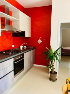 a kitchen with a red accent wall and a stove at Maria Pia's home in Marotta +21 photos