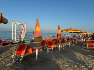 a group of chairs and umbrellas on a beach at Maria Pia's home in Marotta