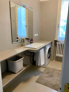 a bathroom with a sink and a washing machine at Maria Pia's home in Marotta