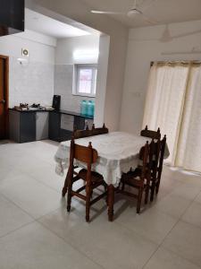 a dining room with a table and a kitchen at Green fields in Vijayawāda