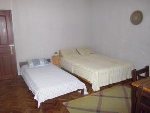 a room with two beds and a table at Dimi HOUSE in Andasibe
