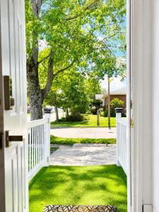 an open door to a yard with a tree at Cozy 2-Bedroom Suite Near Moncton Hospital & NBCC in Moncton