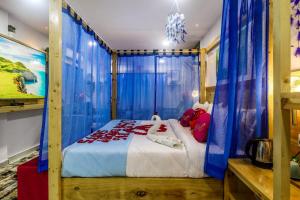 a bedroom with a large bed with blue drapes at DSR Blue Suites in Hyderabad