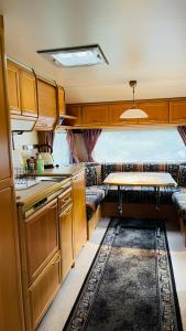 a kitchen and a living room with a couch at Caravan at the Cottage House in Ertenvåg