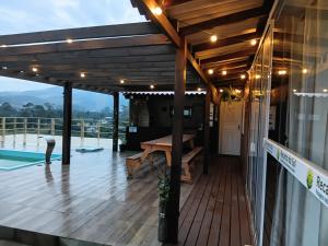 a wooden deck with a bench on a house at Recanto do sol in Imaruí