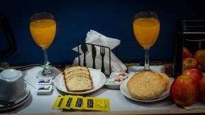 a table with two glasses of orange juice and food at Bellas Artes Palace Secret Suites Adult Only in Santiago