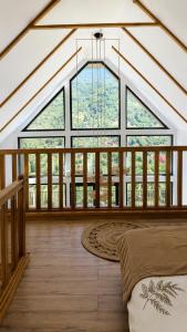 a large room with a large window and a bed at Triovista Chalets in Nehoiu