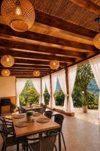 a dining room with tables and chairs and windows at Triovista Chalets in Nehoiu