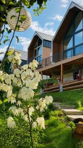 a house with a tree in front of it at Triovista Chalets in Nehoiu