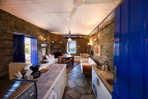 a kitchen and living room with a couch and a table at Stone house with a magical view in Otziás