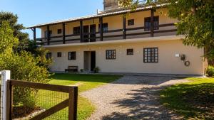 an old house with a fence in front of it at GH Pinheira in Palhoça