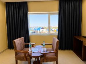 a dining room with a table and two chairs and a window at Hotel bhawani palace Pipalkoti in Pīpalkoti