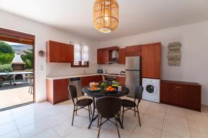 a kitchen with a table and chairs in a kitchen at Lindos Aeonian Villas in Lindos