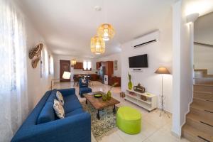 a living room with a blue couch and a table at Lindos Aeonian Villas in Lindos