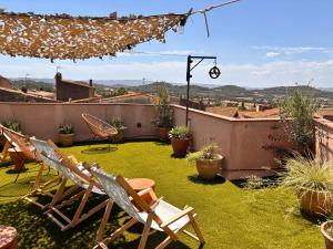 a patio with chairs and a view of the city at El Fort d'Ullastret in Ullastret +20 photos