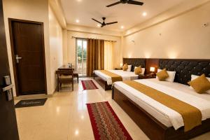 a hotel room with two beds and a window at Hotel bhawani palace Pipalkoti in Pīpalkoti