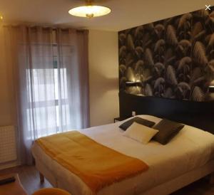 a bedroom with a large bed with a large wall at LE RELAIS DU mene in Le Gouray