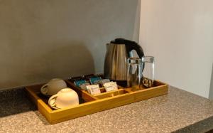 a wooden tray with a coffee pot on a counter at At Kelly's Ambalangoda in Ambalangoda