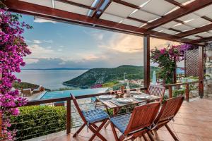 a patio with a table and chairs and a view of the ocean at Elies Houses in Agnontas
