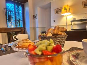 a table with a basket of bread and a basket of fruit at Le Clos du Cerf in Cellettes