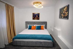 a bedroom with a bed with orange and blue pillows at Le Charme Boutique in Bucharest