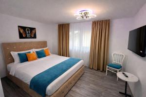 a bedroom with a bed and a flat screen tv at Le Charme Boutique in Bucharest
