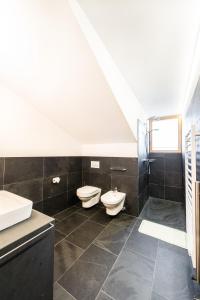 a bathroom with two toilets and a sink at Gasthof Zur Sonne in Laion +45 photos