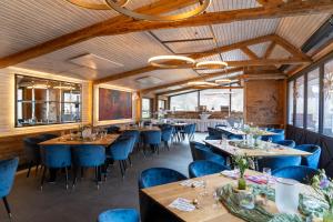 a dining room with tables and blue chairs at Schössersmühle in Eisenberg