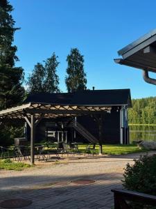 a pavilion with tables and chairs in front of a building at Norppa Lake Resort in Savonlinna