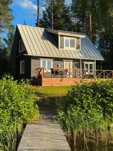 a house with a wooden walkway in front of it at Norppa Lake Resort in Savonlinna