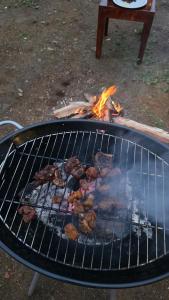 a grill with some meat cooking on it at Fiddlehead Fern in Kurchi +17 photos