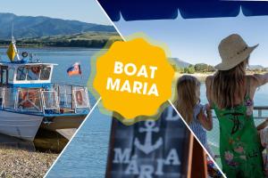 two women are looking at a boat marina at Mara Lake Cabins - Mara Camping in Liptovský Trnovec