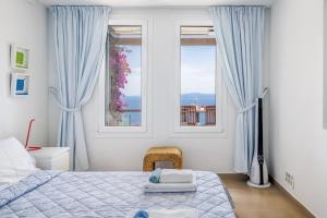 a bedroom with blue curtains and a bed and a window at Elies Houses in Agnontas +64 photos