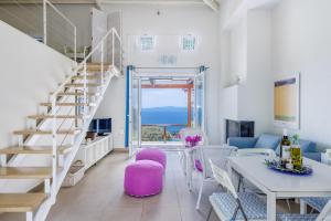 a living room with a staircase and a table and chairs at Elies Houses in Agnontas