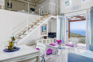 a room with a staircase and a table and chairs at Elies Houses in Agnontas