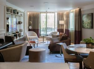 a living room with couches and chairs and a table at The Guardsman Hotel in London