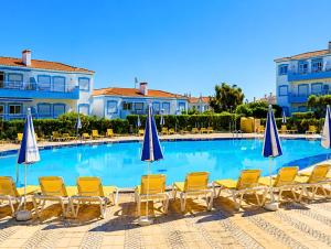 a large swimming pool with chairs and umbrellas at Apartamento Oásis Parque 3 in Portimão