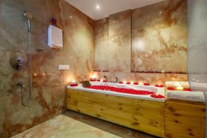 a bathroom with a tub filled with red roses at DSR Pink Suites in Hyderabad +9 photos