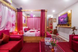 a bedroom with a bed with pink curtains and a tv at DSR Pink Suites in Hyderabad