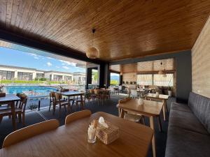 a restaurant with tables and chairs and a pool at Modern House in Solotvyno